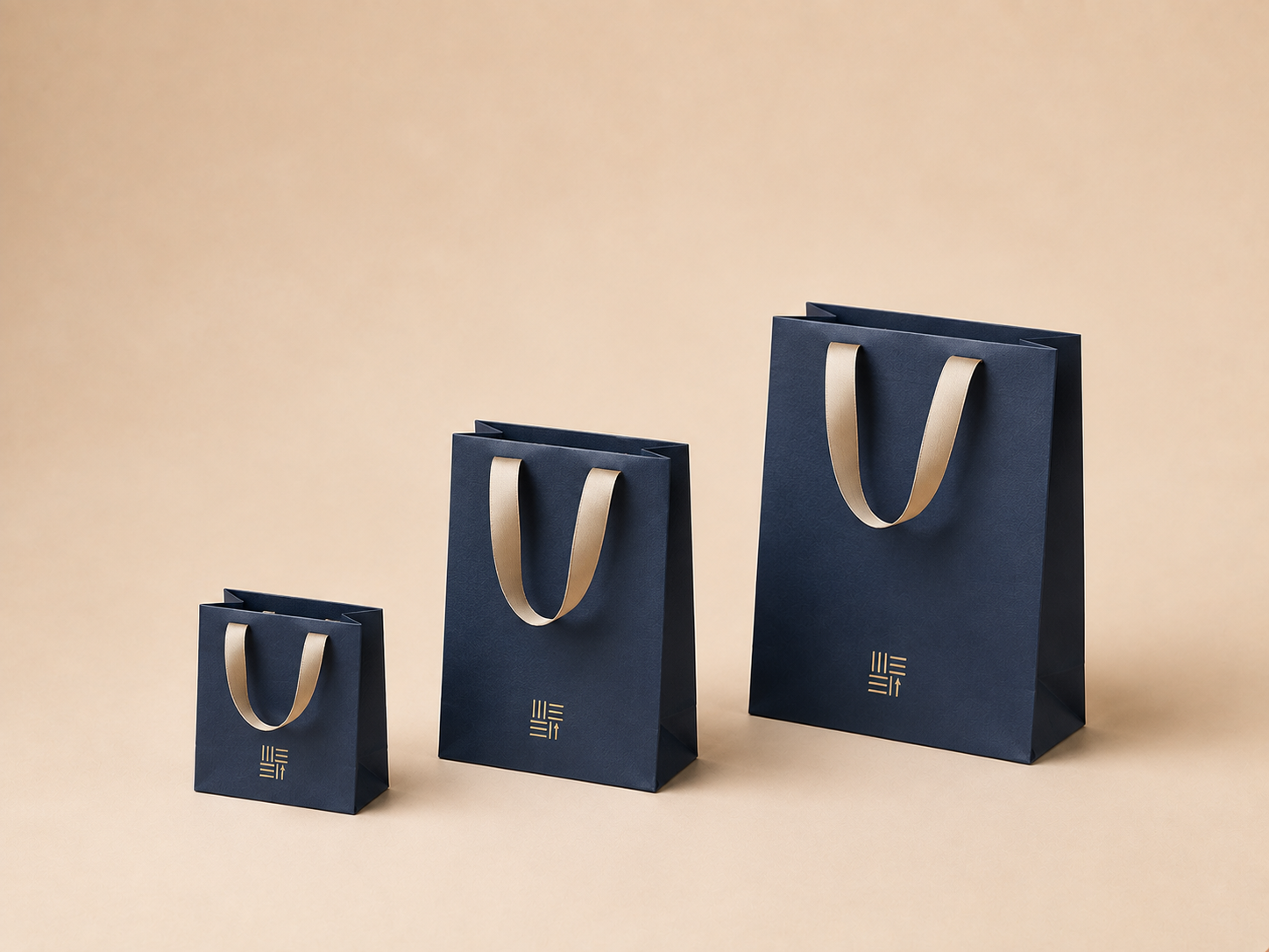 Navy jewelry paper bags with cream ribbon handles in three sizes